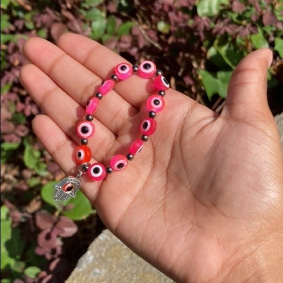 The color is Pink The design includes a hand charm abs a evil eye charm - Picture 2 of 4